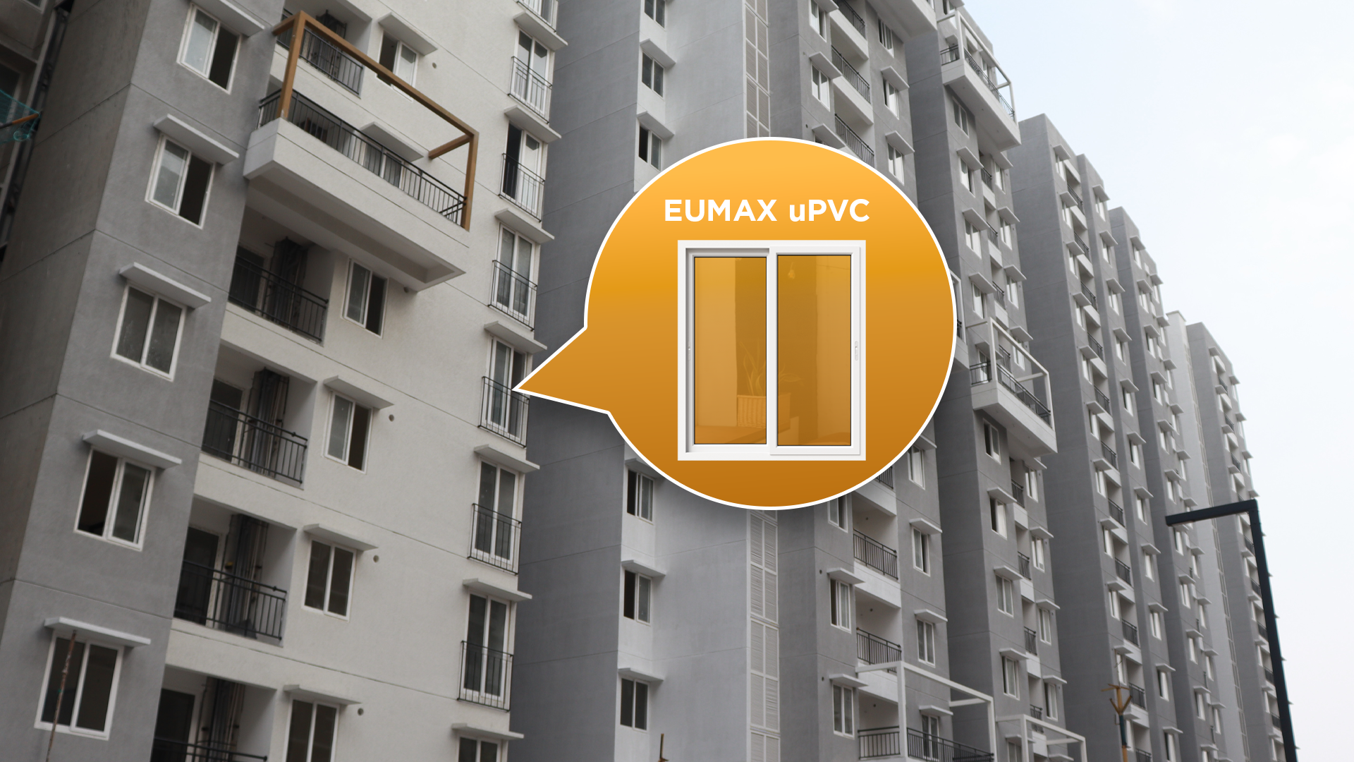 A multi-storey residential apartment block with a callout highlighting a white Eumax uPVC sliding window in the facade